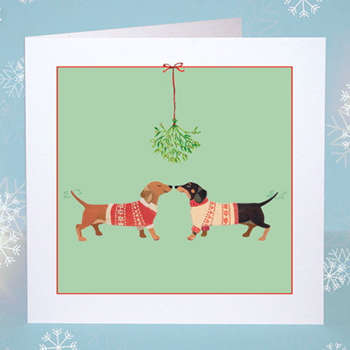 Sausage Dogs Christmas Card Original Christmas card featuring two dachshund dogs in Christmas jumpers under the mistletoe. Green background.